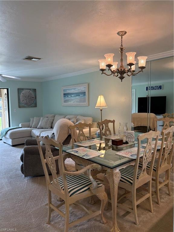 Carpeted dining space featuring a chandelier, crown molding, and a ceiling fan
