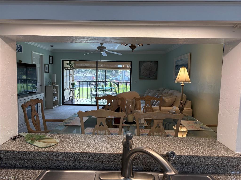 Dining room with a textured wall, ornamental molding, and ceiling fan