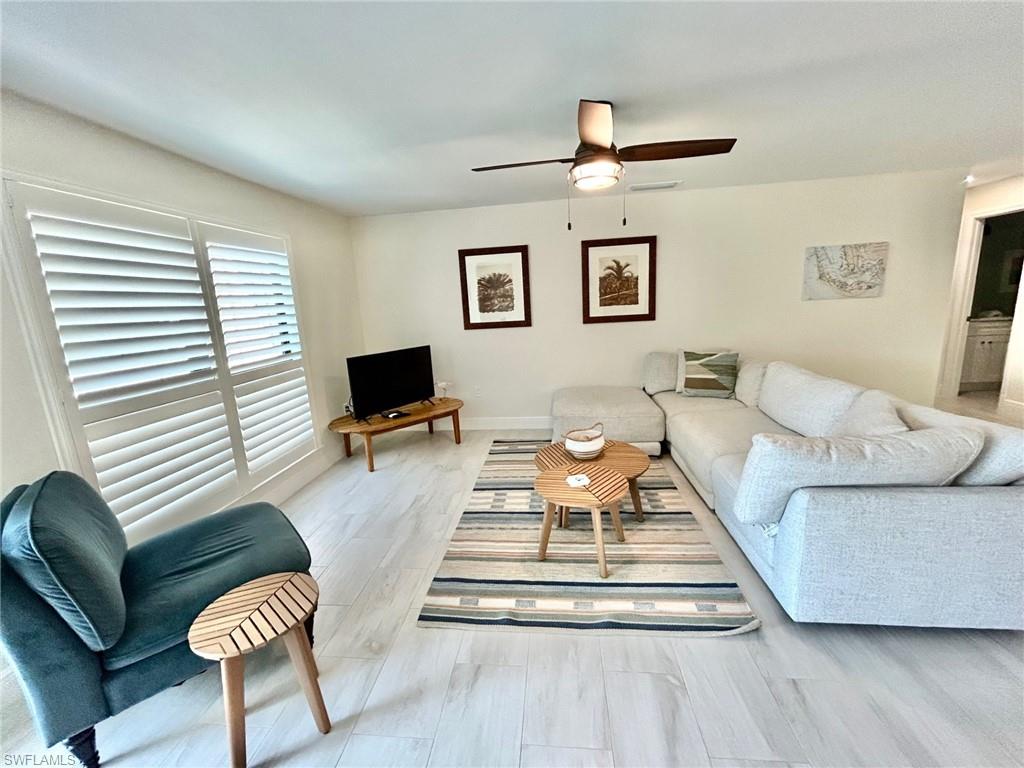 Living area featuring light flooring and ceiling fan