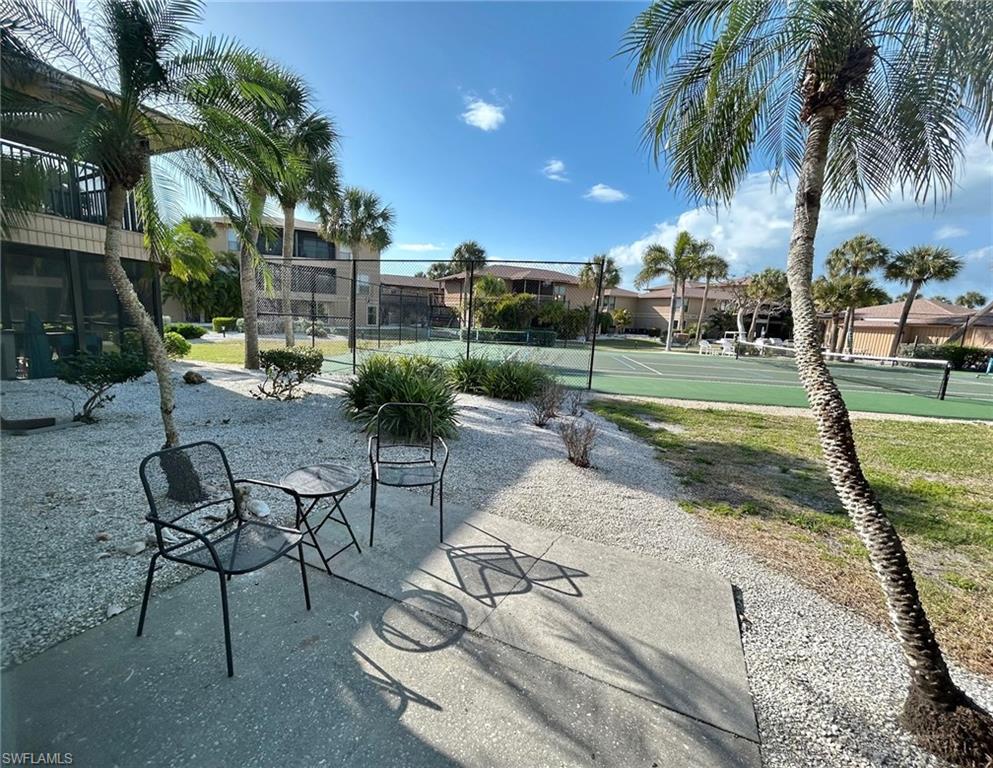 Surrounding community with a tennis court and back patio