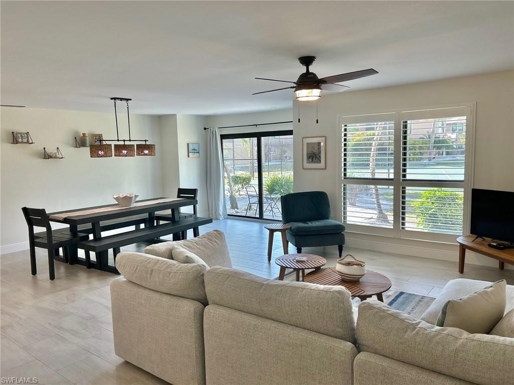 Living room featuring ceiling fan and baseboards
