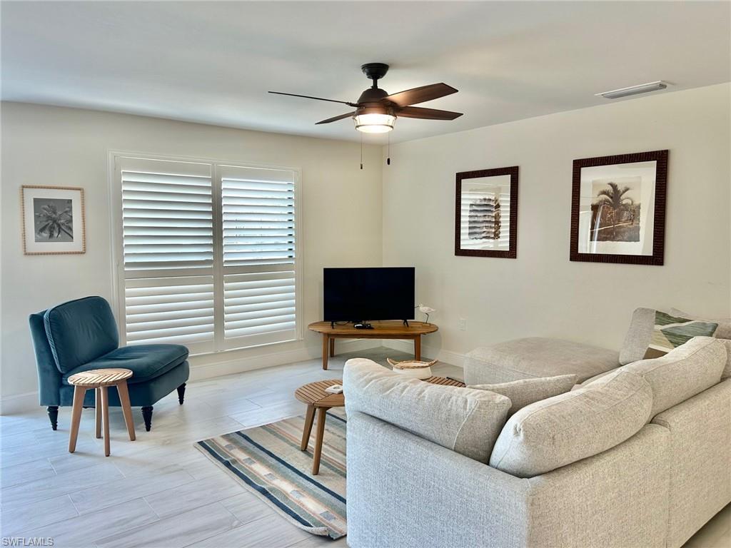 Living area with ceiling fan and baseboards