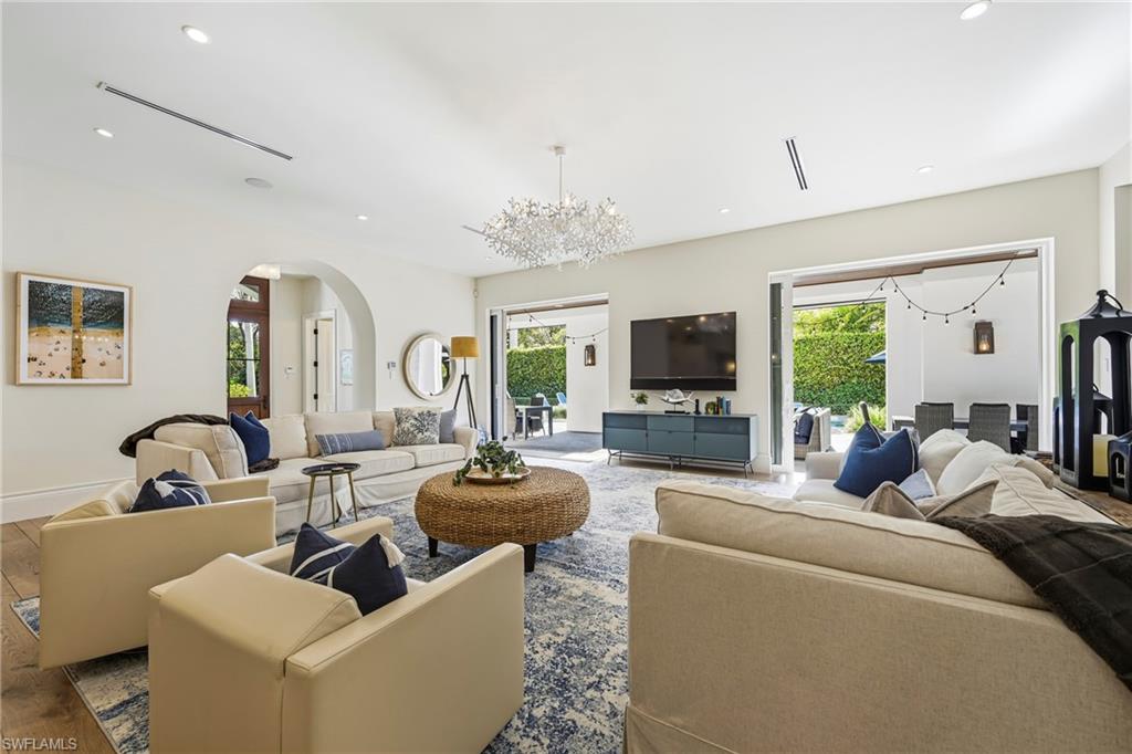 Living room featuring hanging lights, arched walkways, plenty of natural light, and wood finished floors