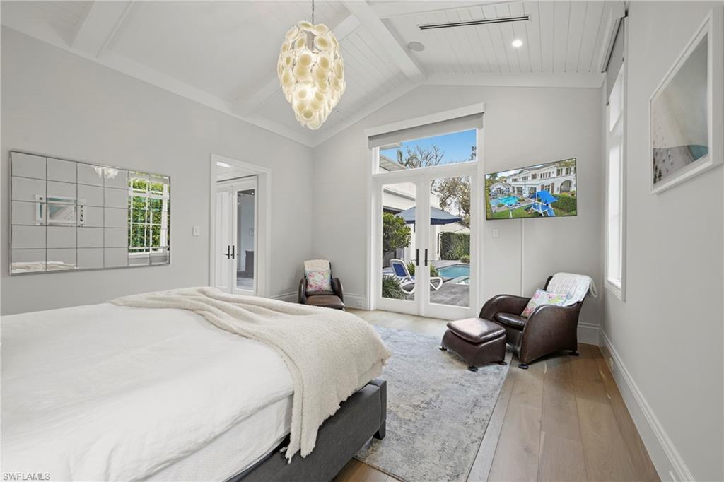 Bedroom with access to exterior, french doors, hardwood / wood-style flooring, and suspended lighting