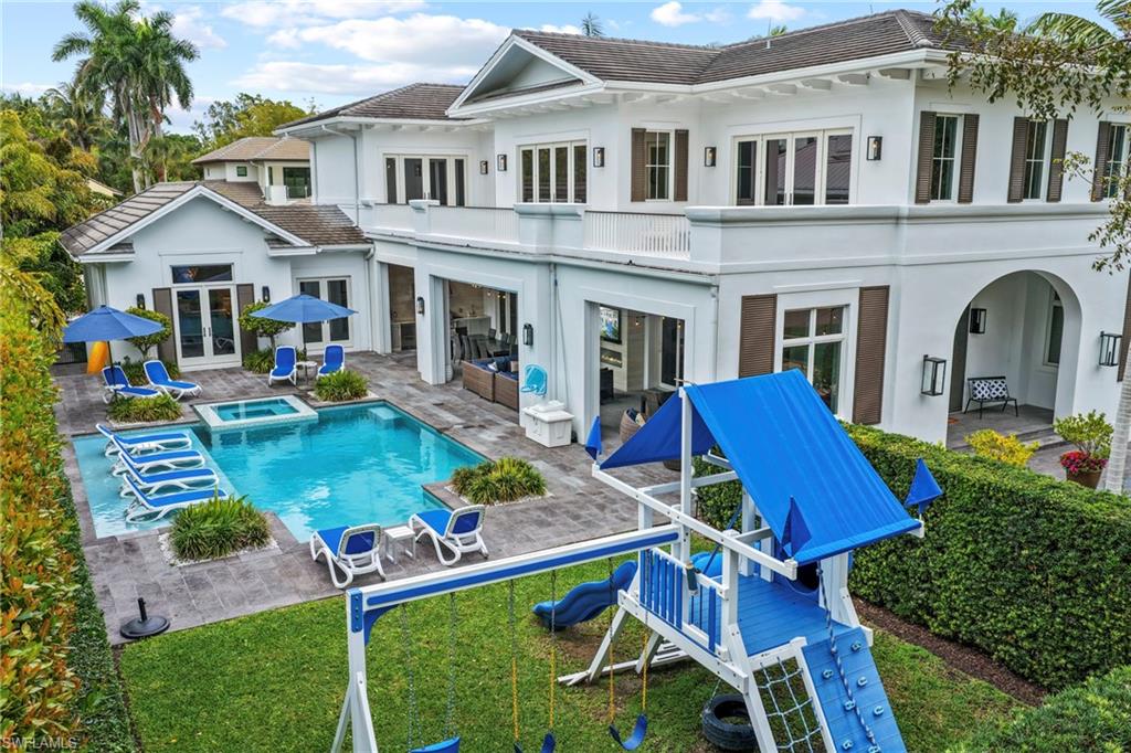 Rear view of property with french doors, stucco siding, a patio area, and a pool with connected hot tub