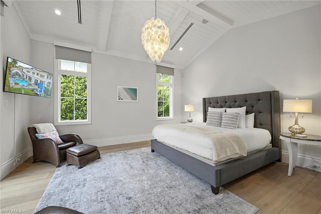 Bedroom with light wood-type flooring, lofted ceiling with beams, and wooden ceiling