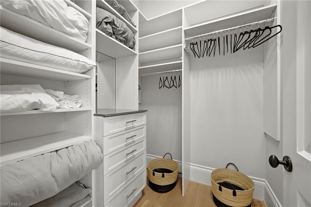 Walk in closet with light wood-type flooring
