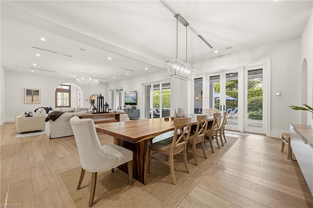 Dining space featuring arched walkways, suspended lighting, and light wood-type flooring