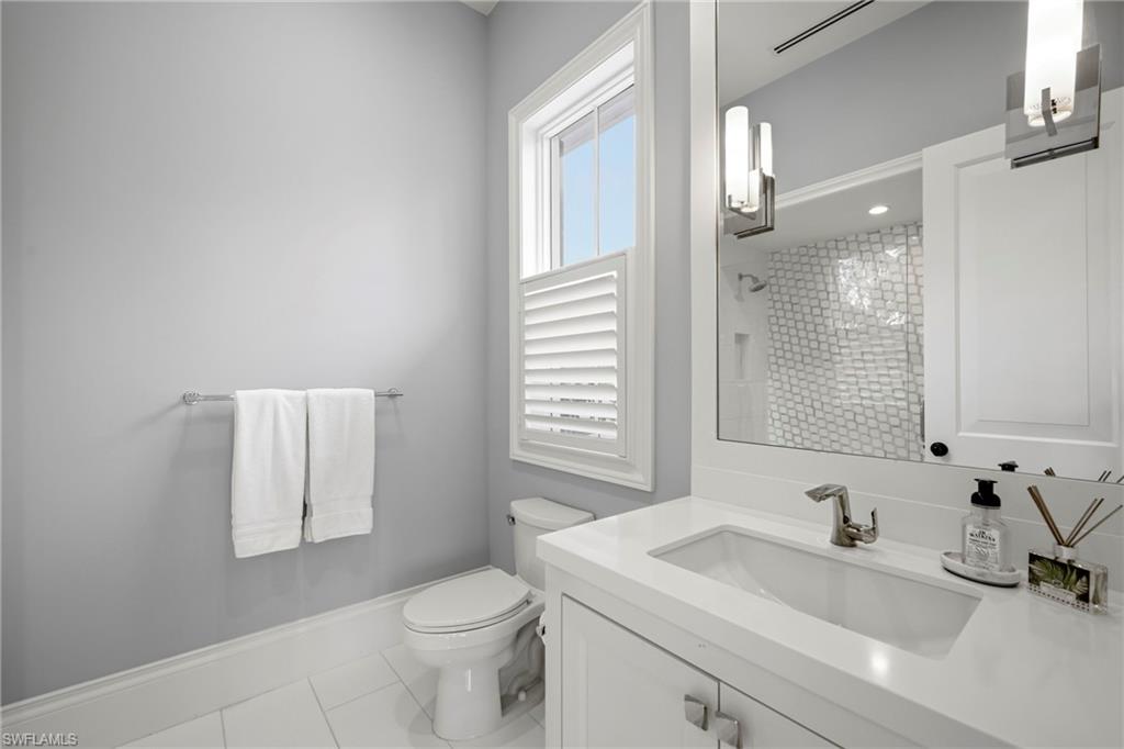 Bathroom with vanity, light tile patterned flooring, and a shower