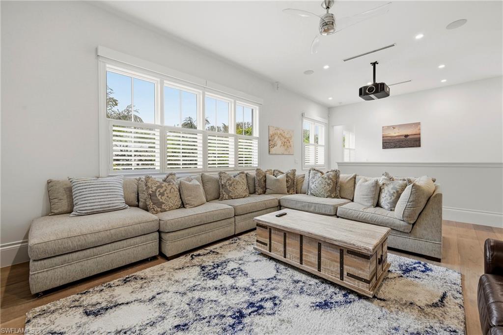 Living room with wood finished floors, a ceiling fan, and recessed lighting