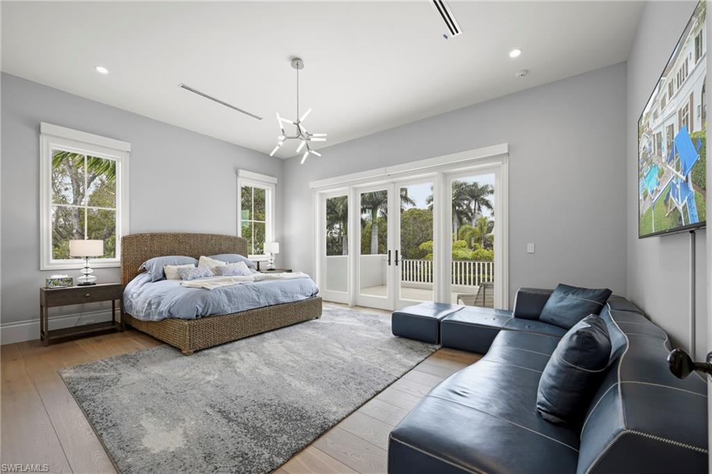 Bedroom featuring light wood-type flooring, access to exterior, and suspended lighting
