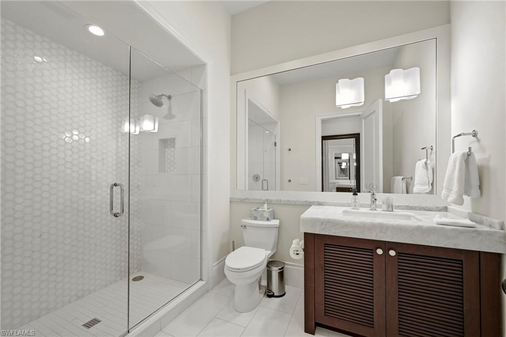 Bathroom with vanity, a stall shower, and light tile patterned flooring
