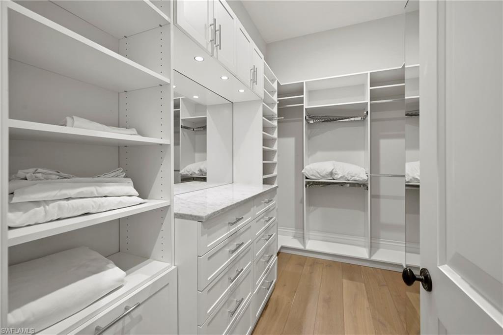 Walk in closet with light wood-type flooring