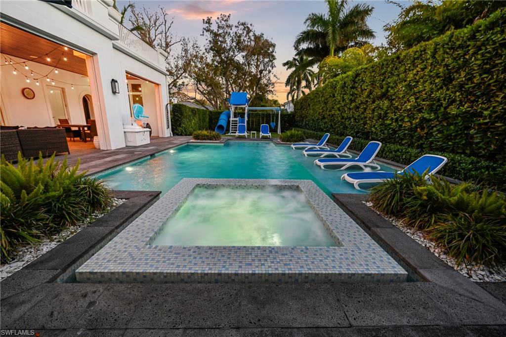 View of pool with patio surround, an in-ground hot tub, and a fenced backyard