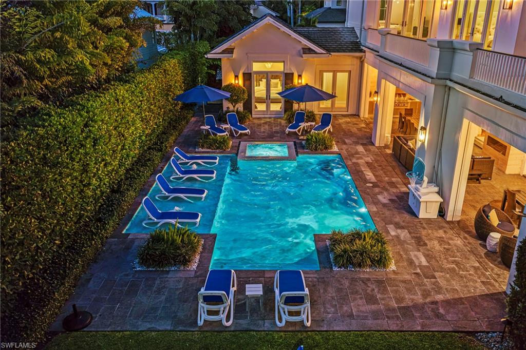 Swimming pool with a patio and an in-ground hot tub