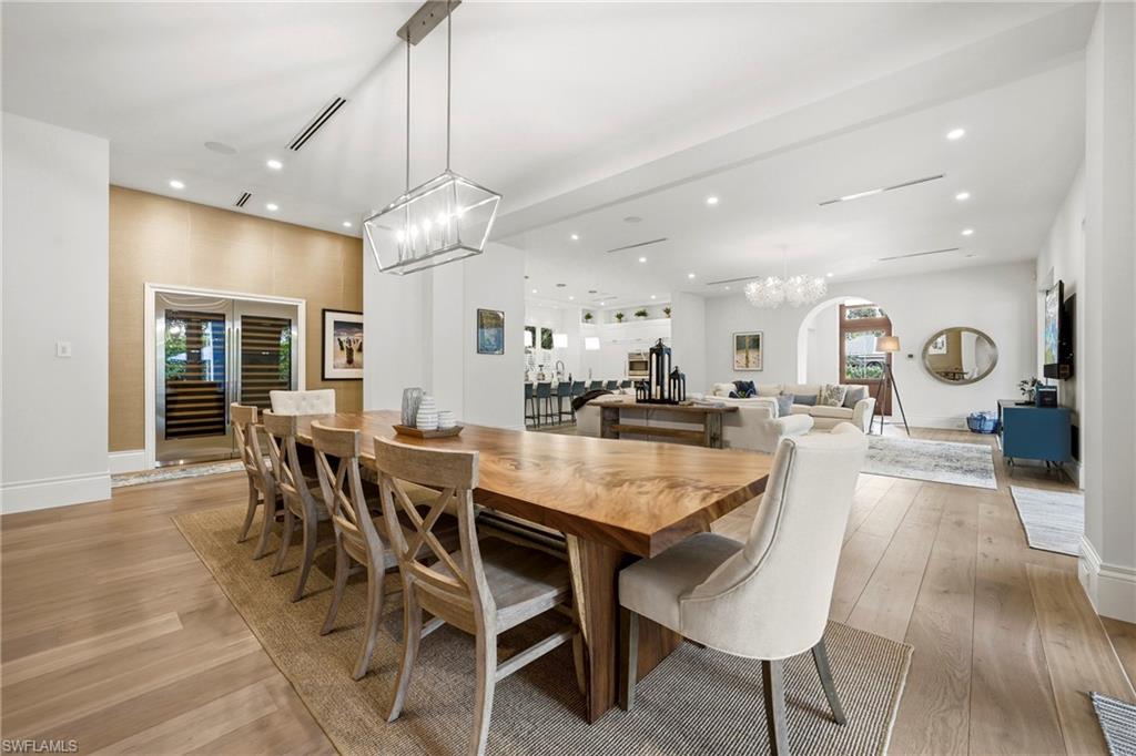 Dining area featuring suspended lighting, light wood finished floors, and arched walkways