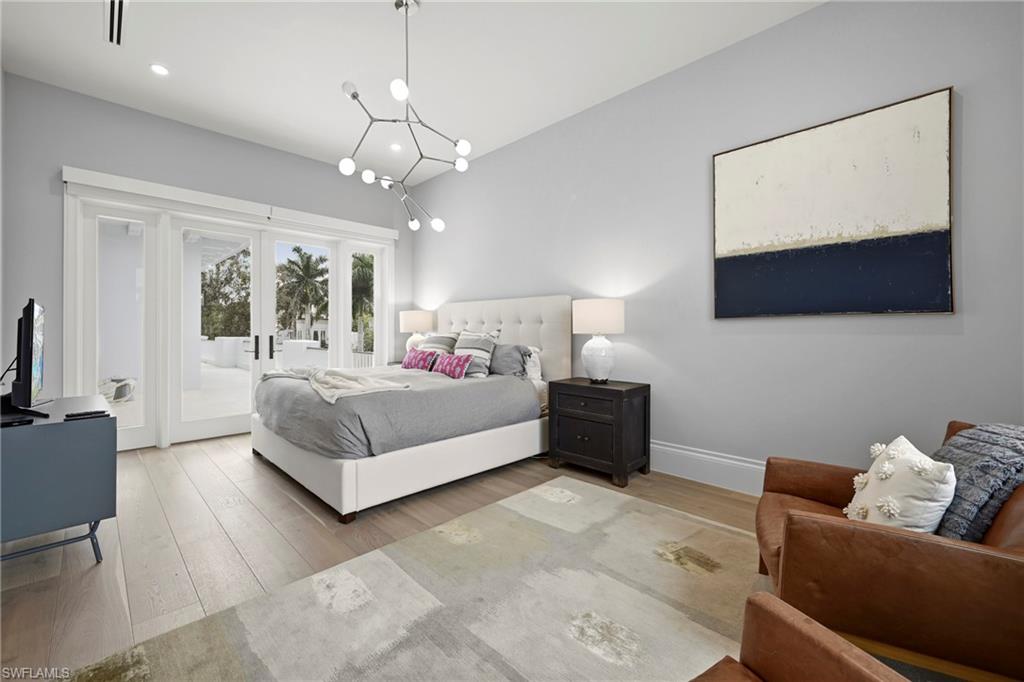 Bedroom with light wood-type flooring, french doors, access to outside, hanging lights, and lofted ceiling