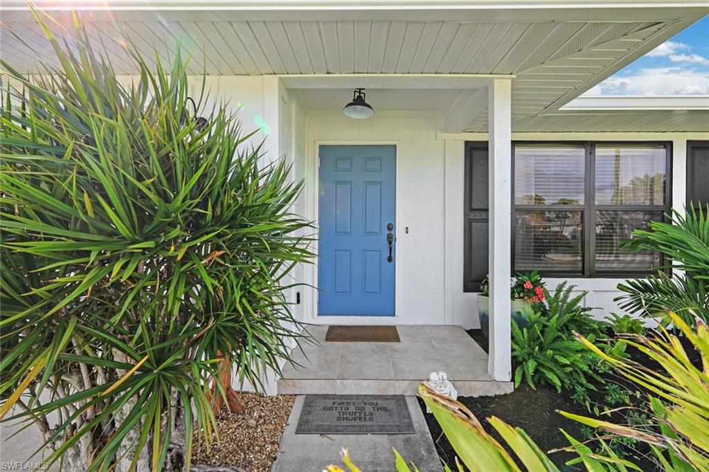 Property entrance with covered porch and stucco siding