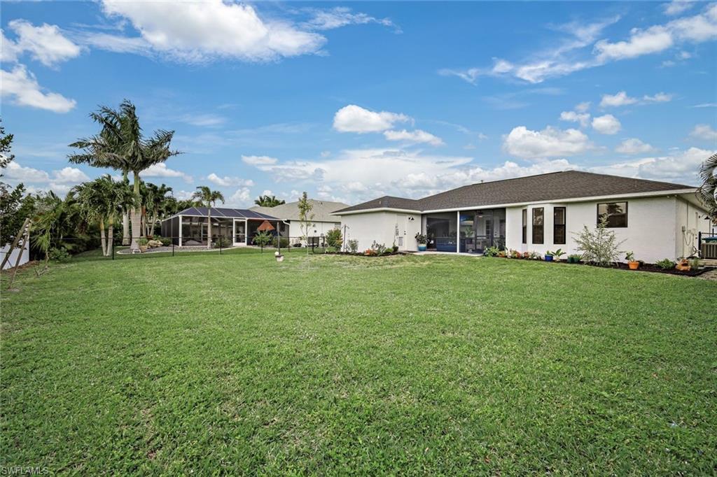 Rear view of house featuring a sunroom and a yard