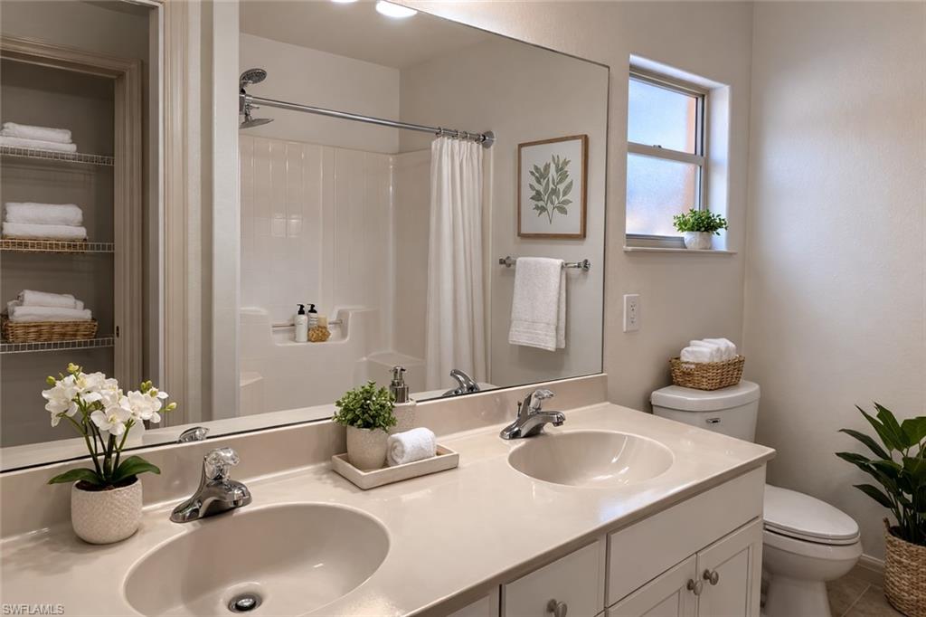 Virtual staged Bathroom featuring double vanity and curtained shower