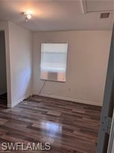 Spare room featuring dark wood-style flooring