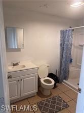 Bathroom with a stall shower, light tile patterned floors, and vanity