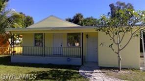 View of front of property with covered porch and a front lawn