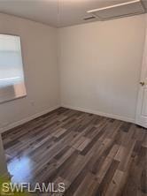 Spare room with dark wood-style floors
