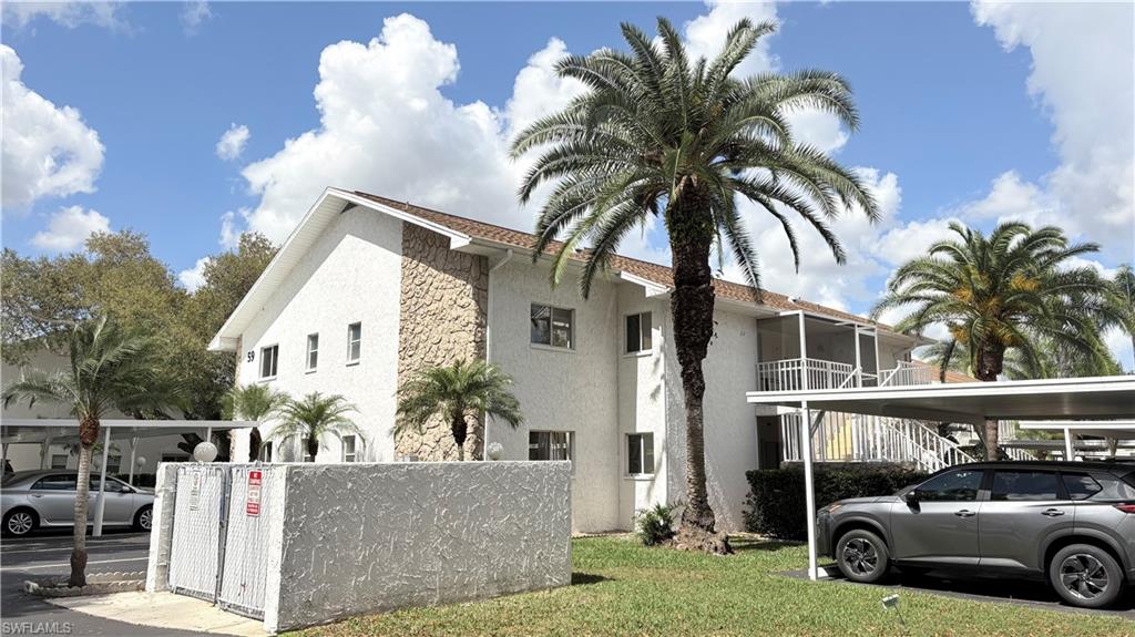View of home's exterior featuring stucco siding, covered parking, and a lawn