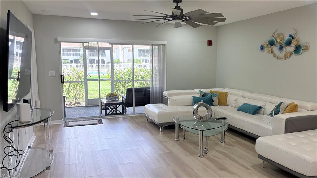Living area with a ceiling fan and light wood-style flooring