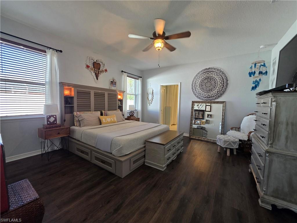 Bedroom with dark wood-style floors, a ceiling fan, and a textured ceiling