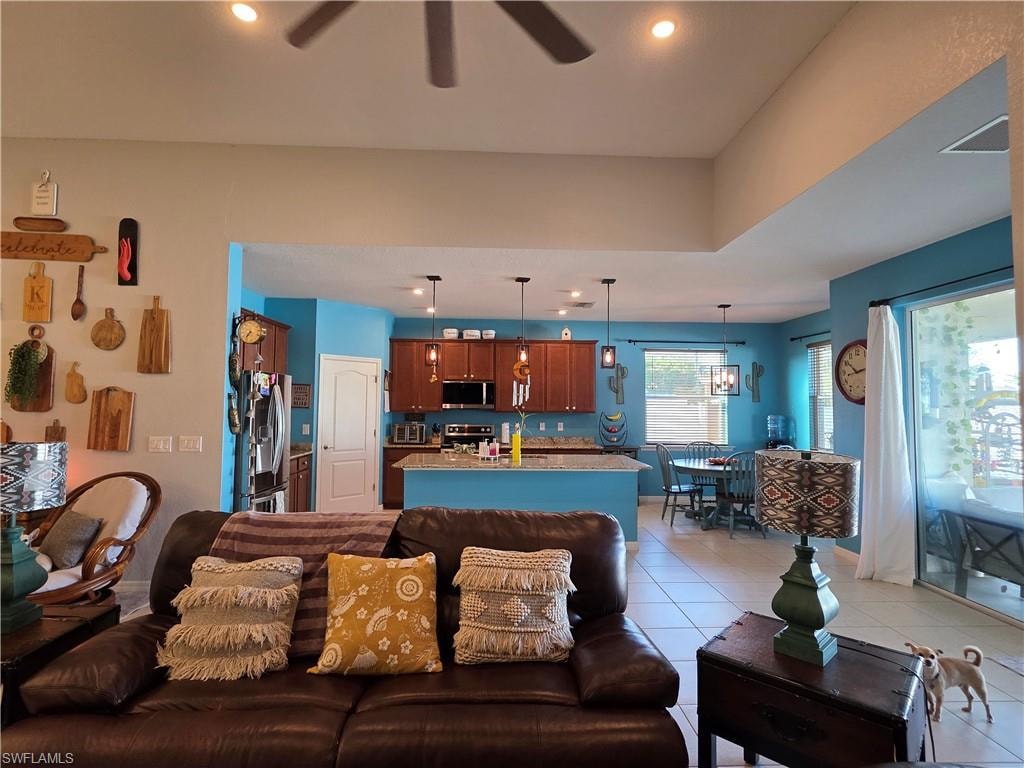Living area featuring a ceiling fan, light tile patterned floors, and recessed lighting