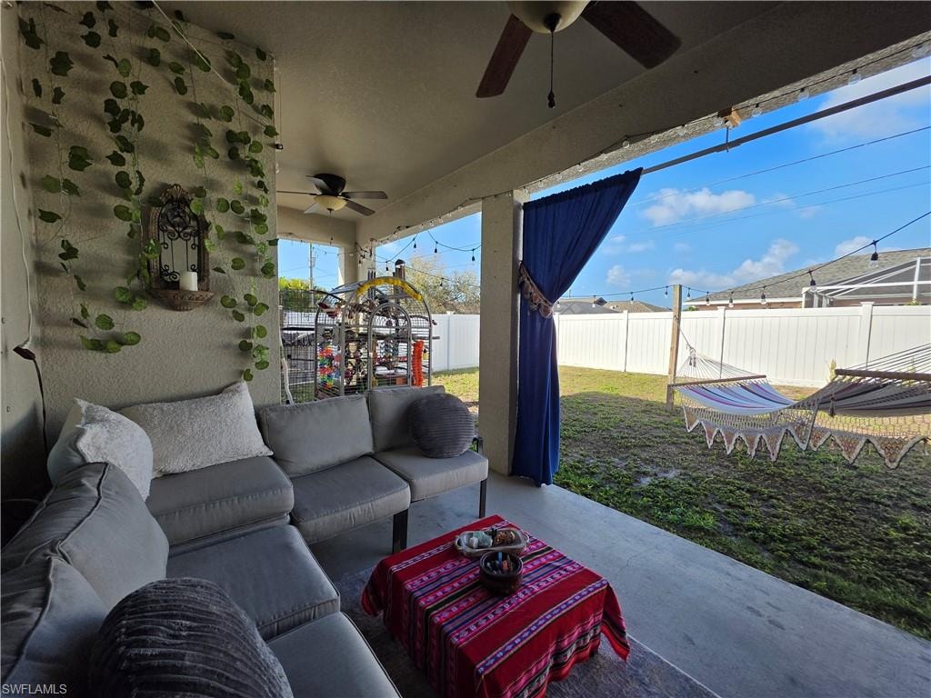Fenced backyard with a ceiling fan, a patio area, and outdoor lounge area