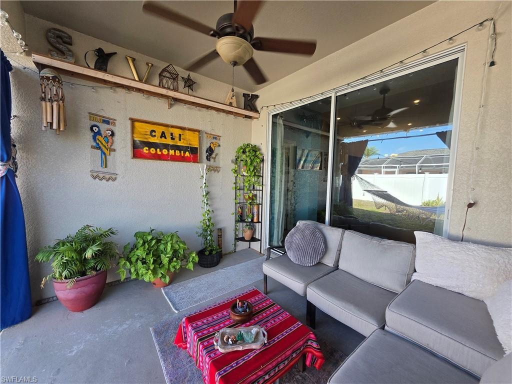 View of patio with an outdoor hangout area and ceiling fan