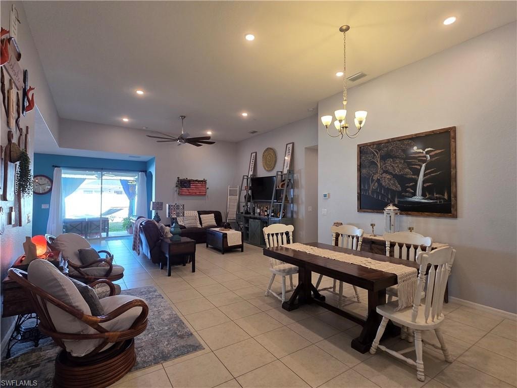 Dining area featuring a ceiling fan, a chandelier, and light tile patterned floors