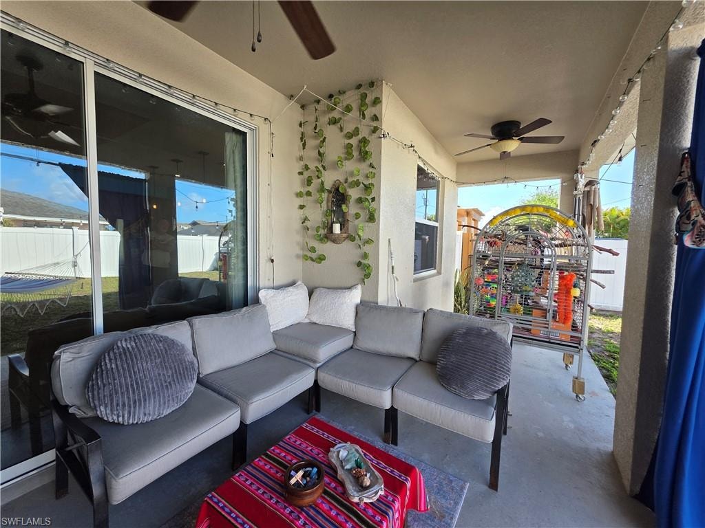 View of patio with outdoor seating and ceiling fan