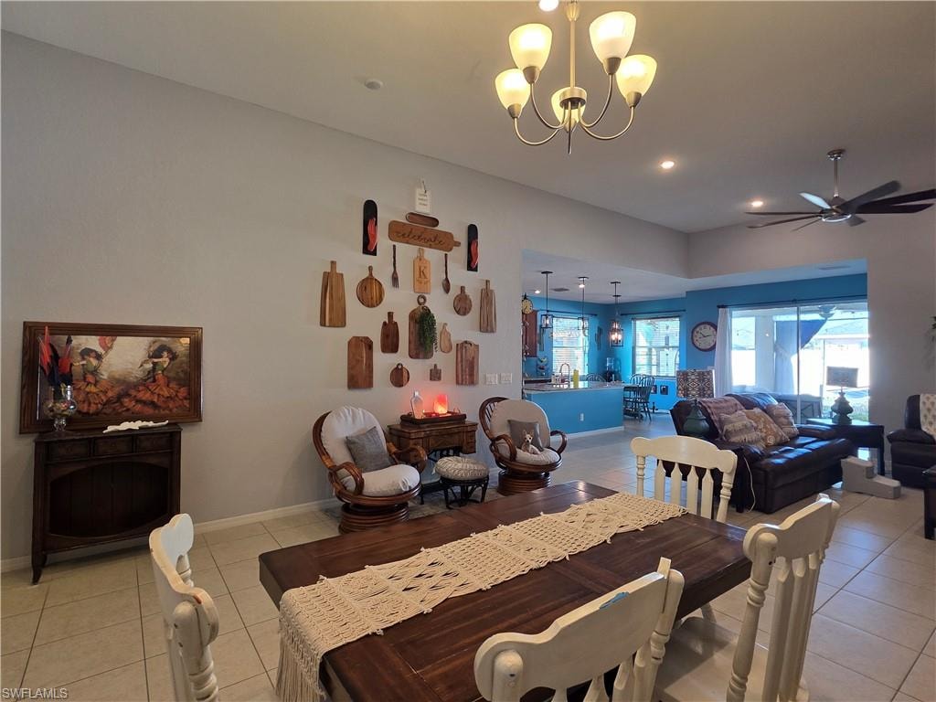 Dining space with light tile patterned flooring, a chandelier, and ceiling fan