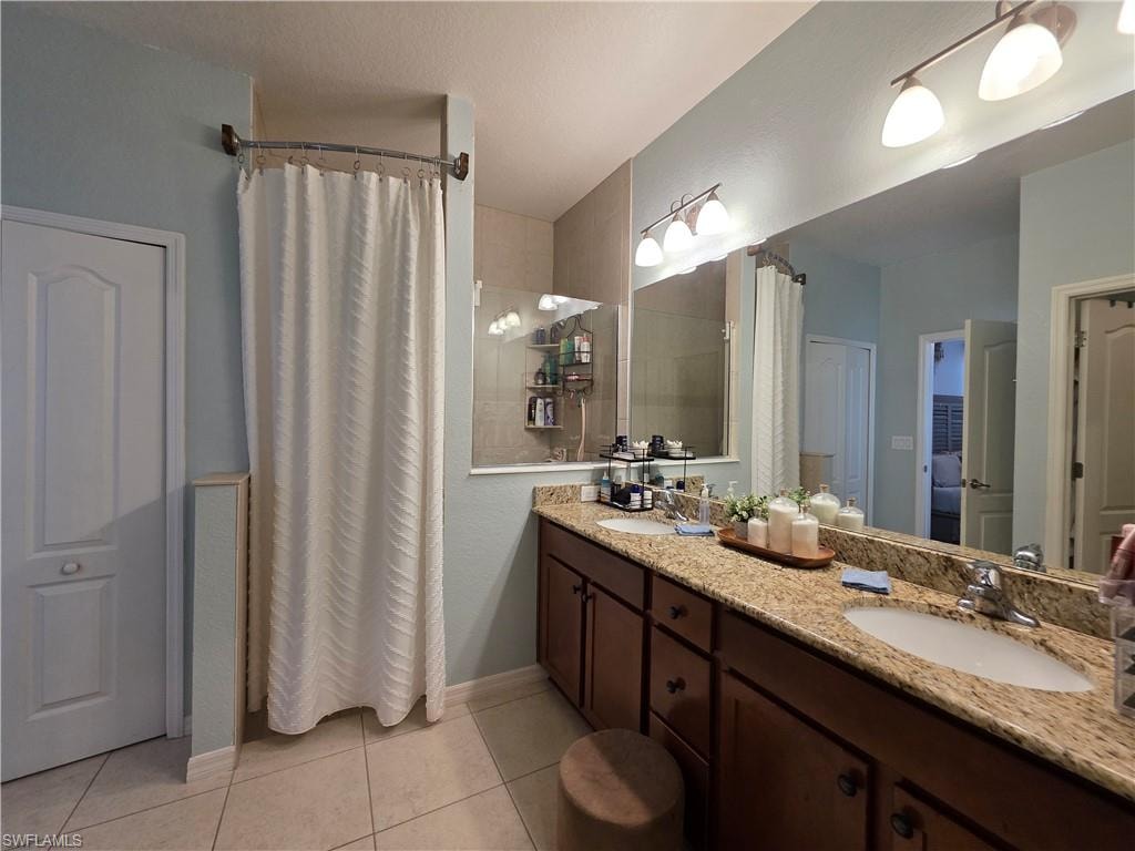 Bathroom featuring double vanity, curtained walk in shower