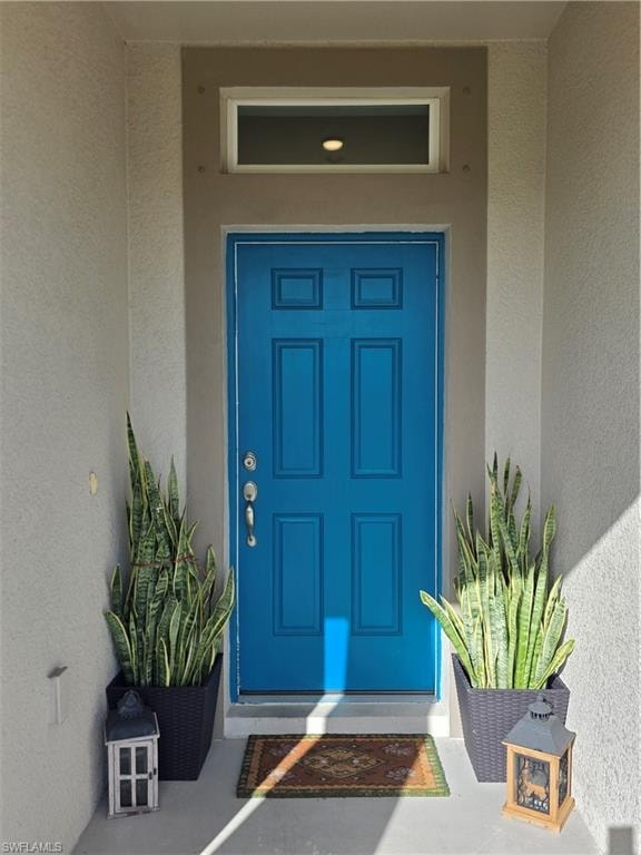 Doorway to property with stucco siding