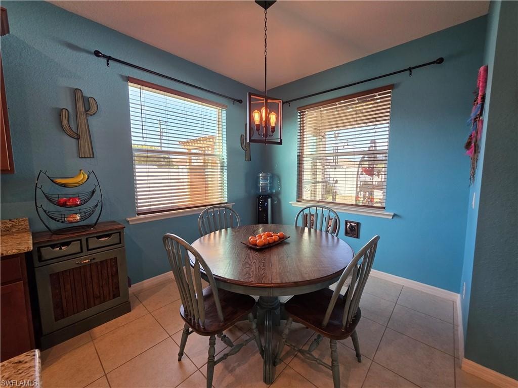 Dining room with light tile patterned flooring and plenty of natural light