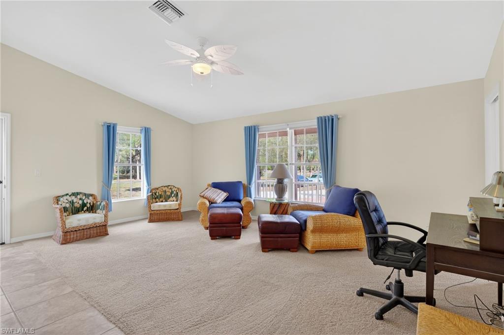 Tiled office featuring carpet flooring, plenty of natural light, ceiling fan, and vaulted ceiling