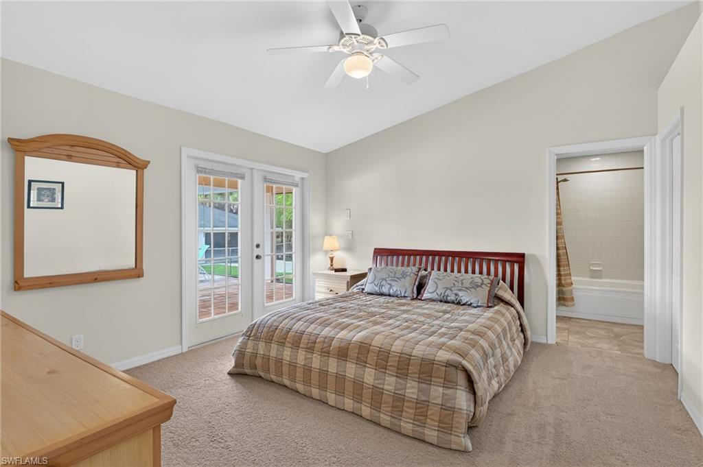 Bedroom featuring vaulted ceiling, access to exterior, light colored carpet, ceiling fan, and french doors
