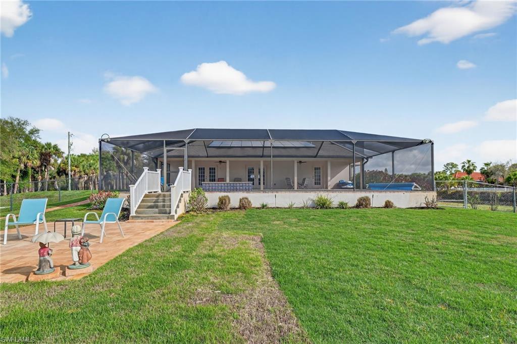 Back of house with a lanai, a fenced backyard, and a patio