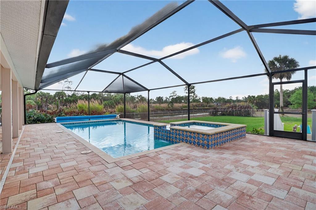 Integrated pool / hot tub featuring a sunroom, a patio, and a lanai