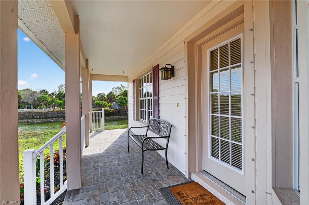 Covered porch featuring a water view