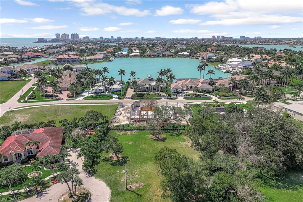 Aerial perspective of suburban area featuring a nearby body of water and city skyline