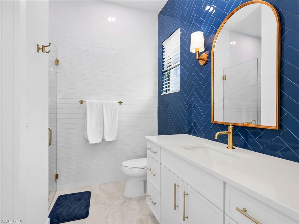 Bathroom with vanity, tile walls, and a shower stall