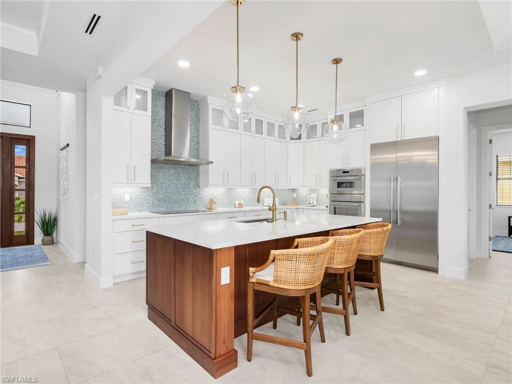 Kitchen featuring healthy amount of natural light, stainless steel appliances, glass fronted cabinets, and dual tone cabinets
