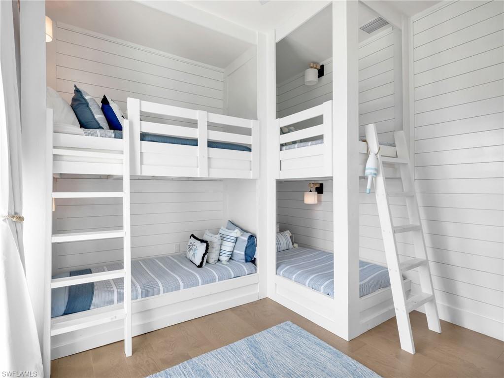Bedroom with wood walls and wood finished floors