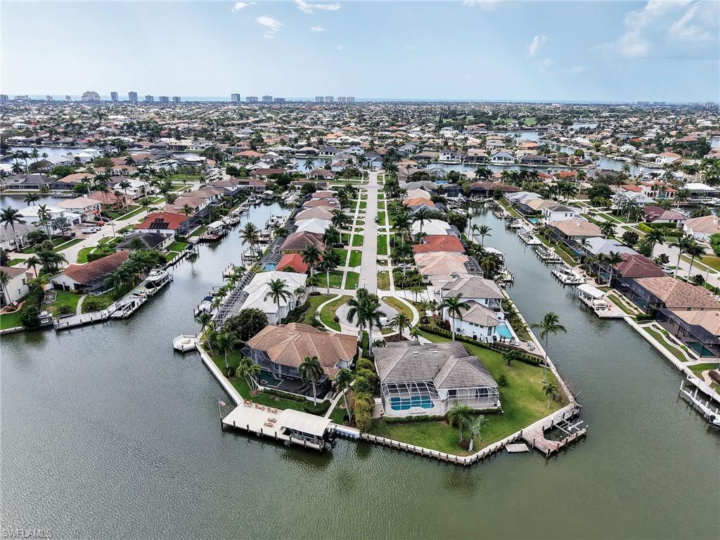 Aerial view of property and surrounding area featuring a large body of water and nearby suburban area